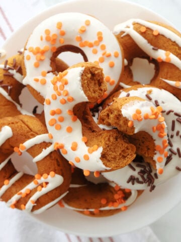 Pumpkin spice donuts arranged on a white plate for serving