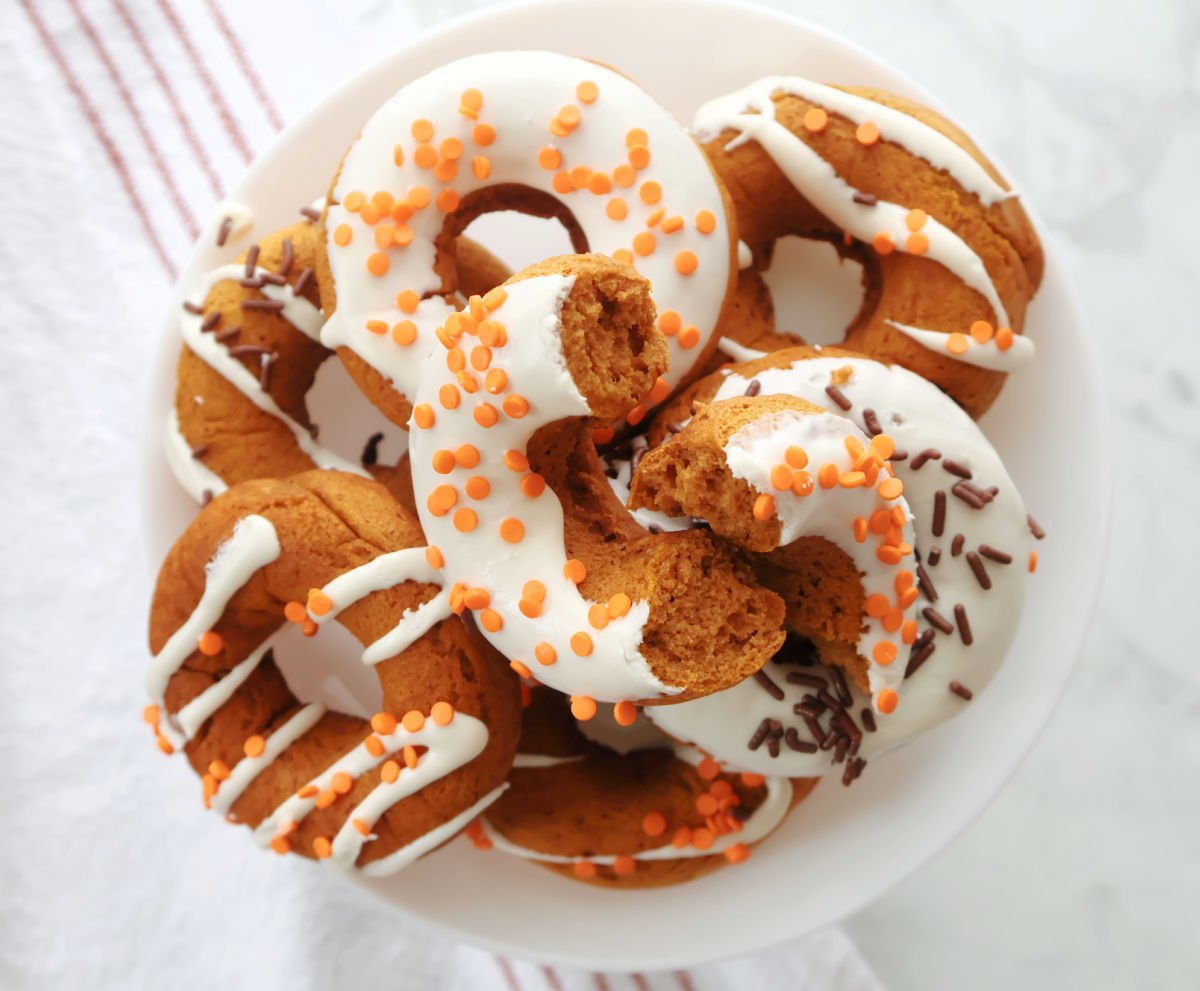 Pumpkin spice donuts arranged on a white plate for serving