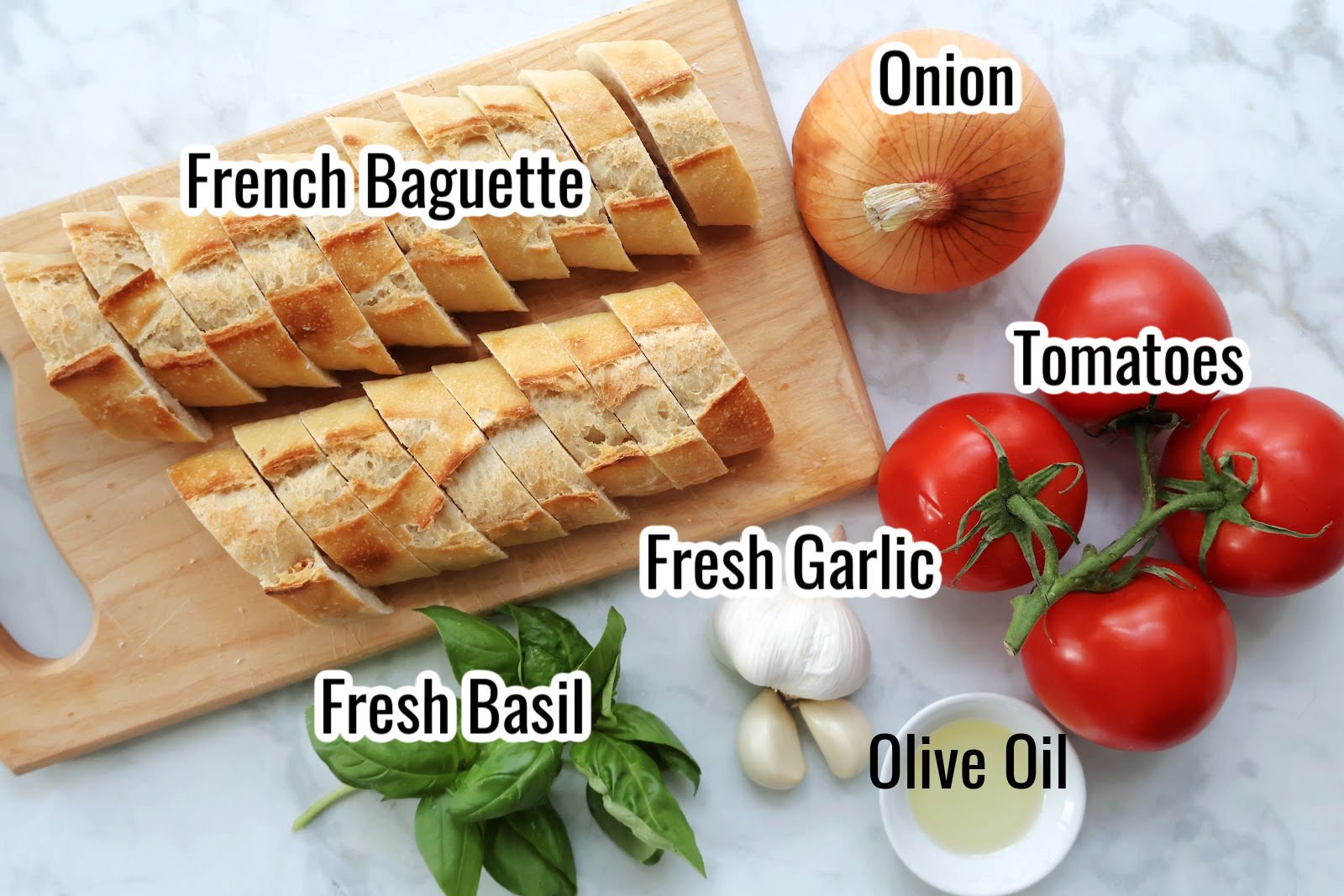 Ingredients for bruschetta including sliced baguette, onion, garlic, basil, tomatoes and olive oil.