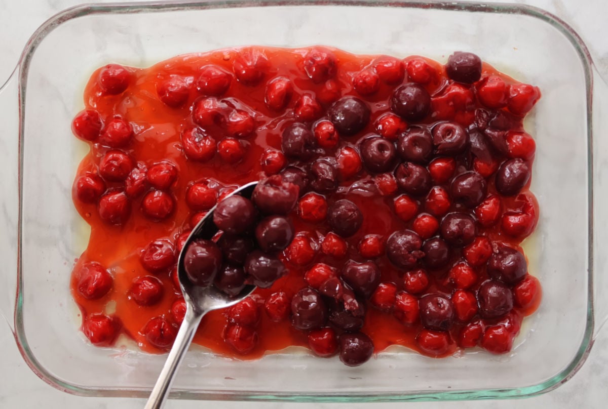 cherry pie filling/topping spread in the bottom of a 9 x 13 pan.