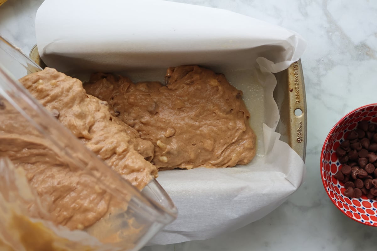 pouring 4 ingredient banana bread batter in loaf pan