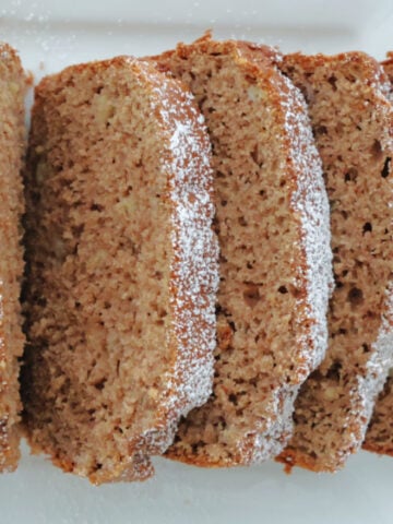 3 ingredient spice cake banana loaf sliced with some sprinkled powder sugar on top.