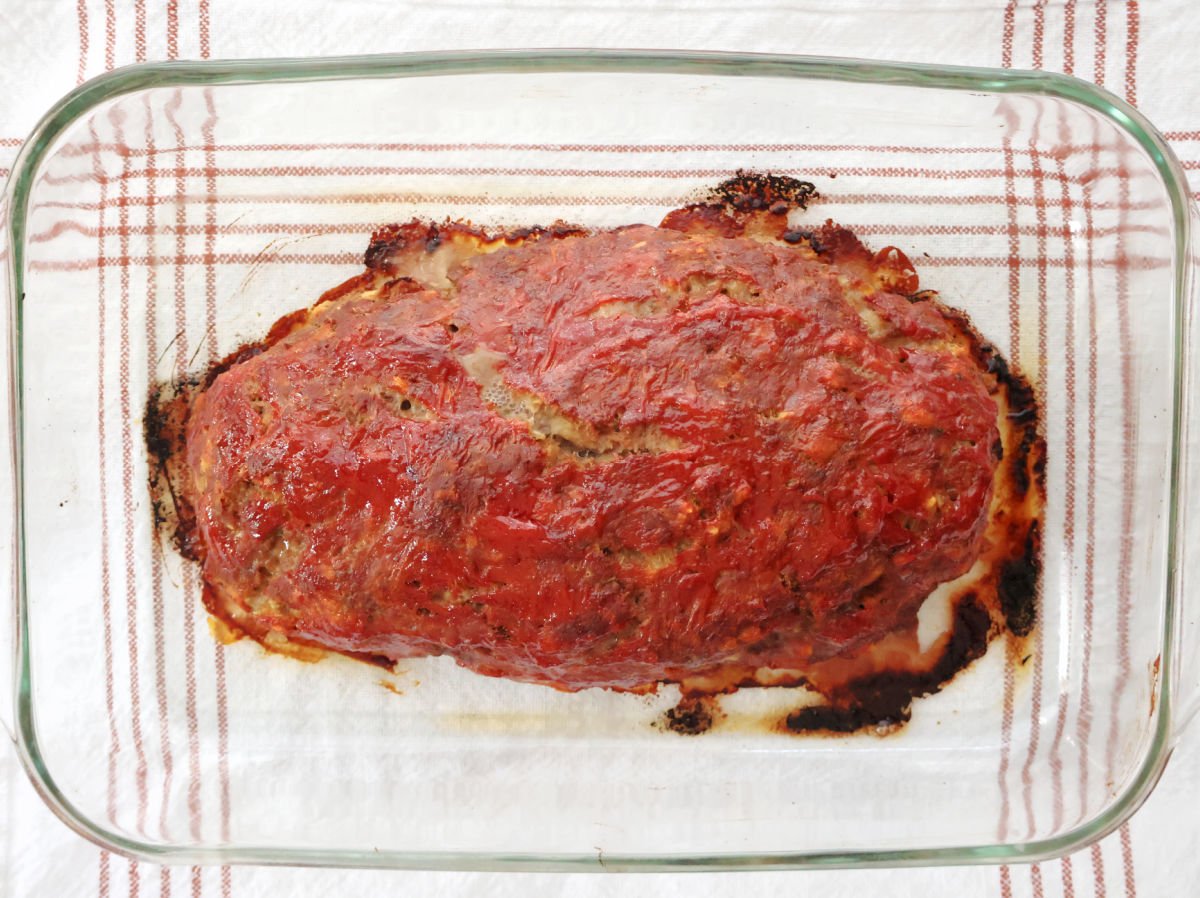 Sliced stovetop stuffing meatloaf on a platter, topped with a glossy ketchup glaze