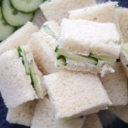 Cucumber sandwiches arranged on white plate with crusts removed