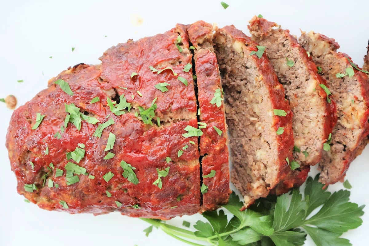 Sliced stovetop stuffing meatloaf on a platter, topped with a glossy ketchup glaze.