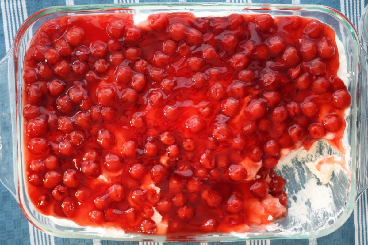Overhead shot of Cherries in the Snow in a baking dish with one serving removed.