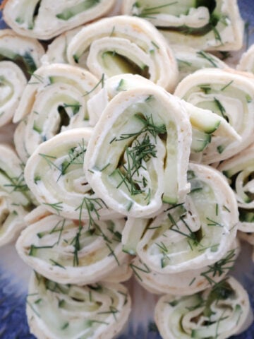 Cream cheese and cucumber tortilla roll ups garnished with chopped dill