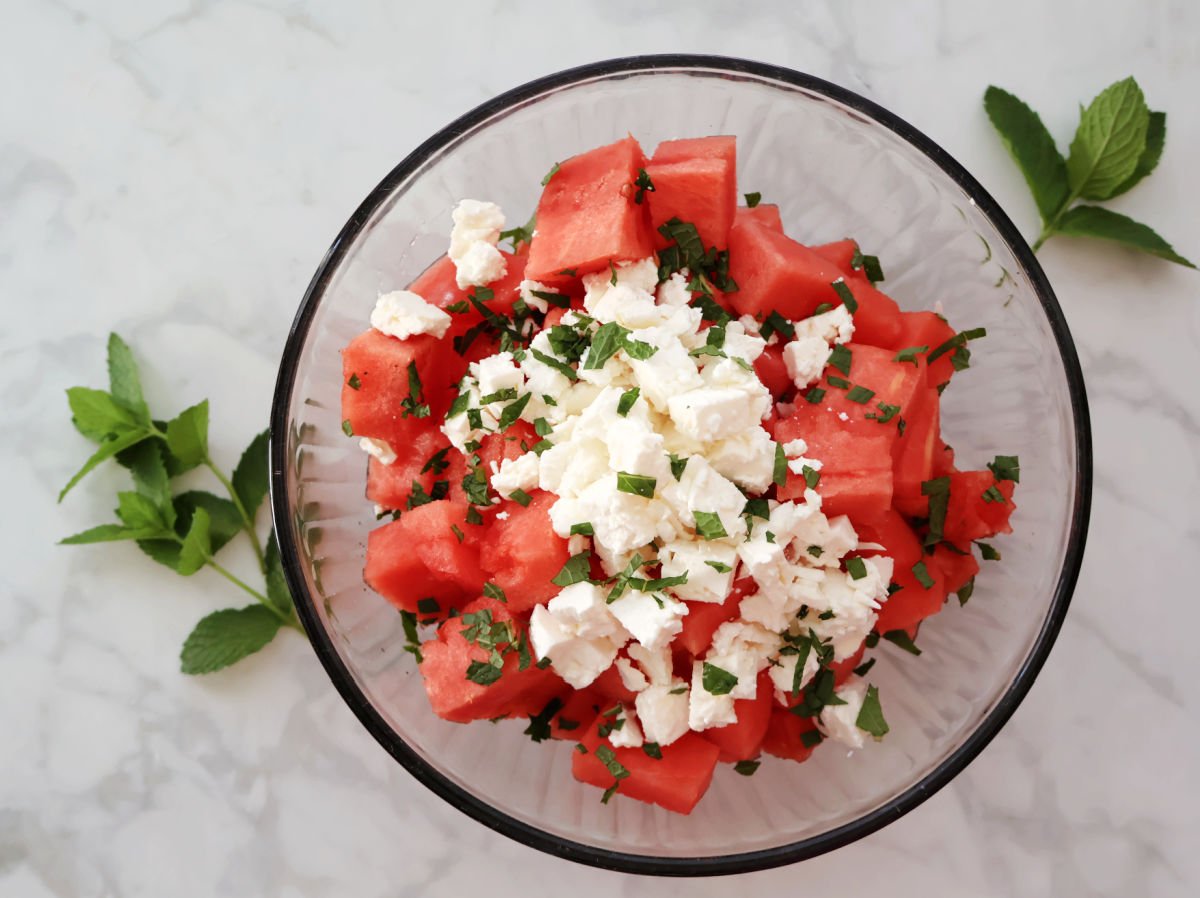 watermelon chuncks, small pieces of feta and fresh mint in a glass bowl.
