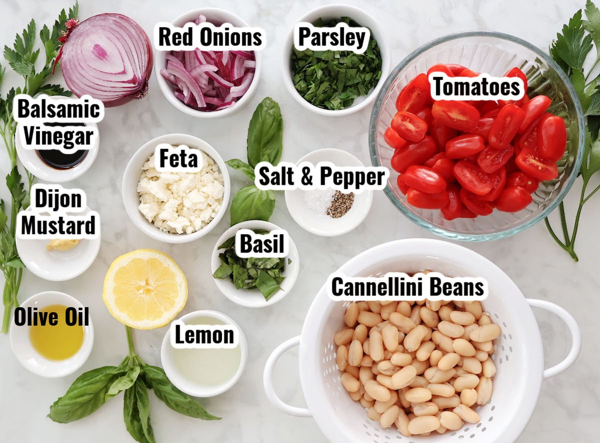 labeled ingredients for white bean and tomato salad (includes cannellini beans, feta cheese and fresh vinaigrette dressing.