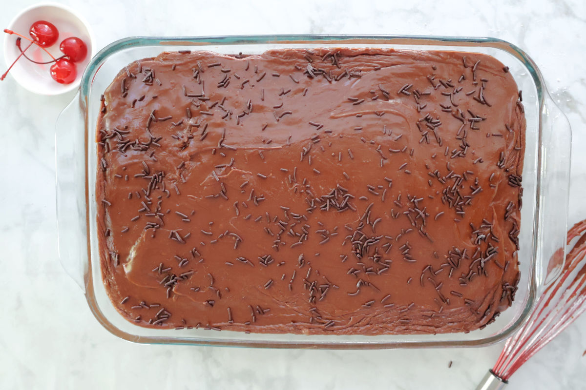 Dr Pepper cake garnished with chocolate sprinkles. Marachino charries on the side.