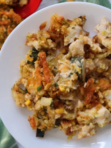 delicious zucchini, chicken and stuffing casserole served up on a white plate.
