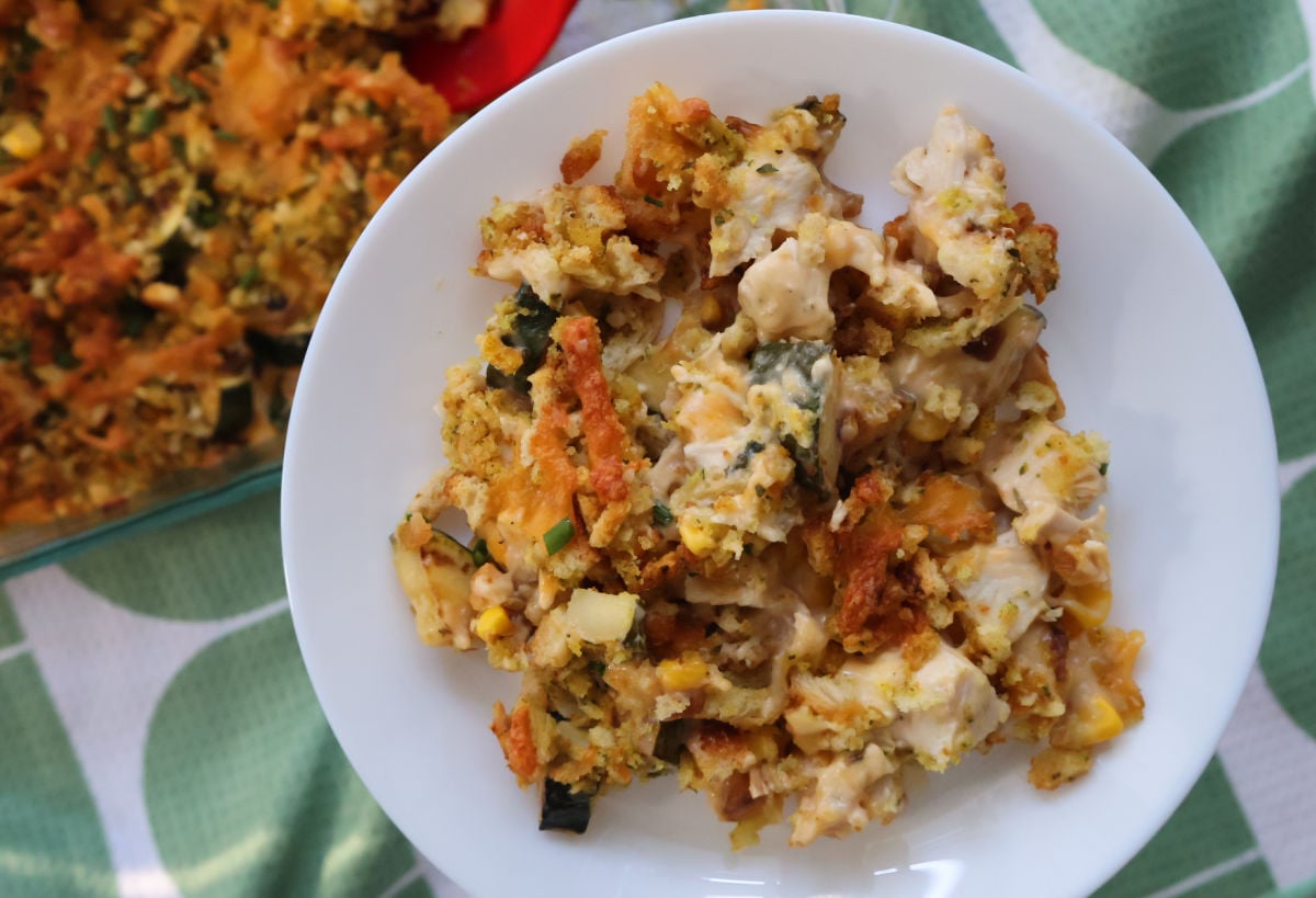 delicious zucchini, chicken and stuffing casserole served up on a white plate.