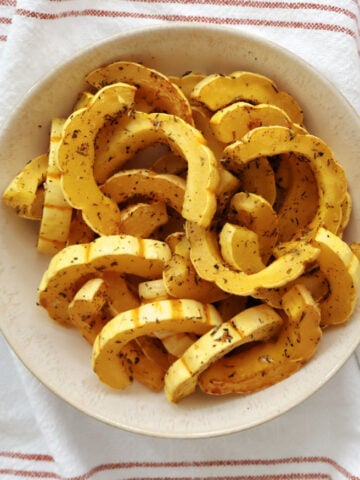 delicata squash slices seasoned with herbs and roasted in the oven.