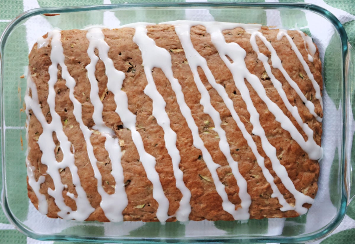 3 ingredient zucchini cake with icing drizzled accross it.
