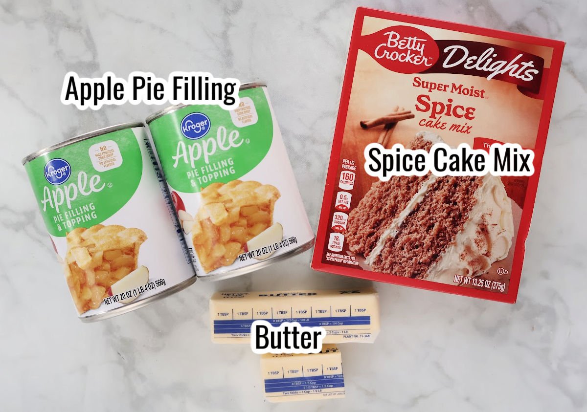 Apple spice dump cake ingredients including spice cake mix, apple pie filling and butter.