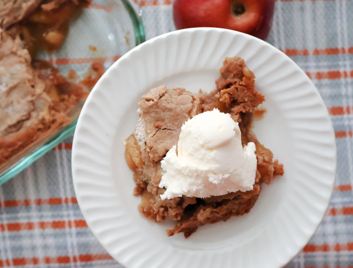 A plate full of Apple Dump Cake made with Spice Cake Mix. Served with a scoop of ice cream.