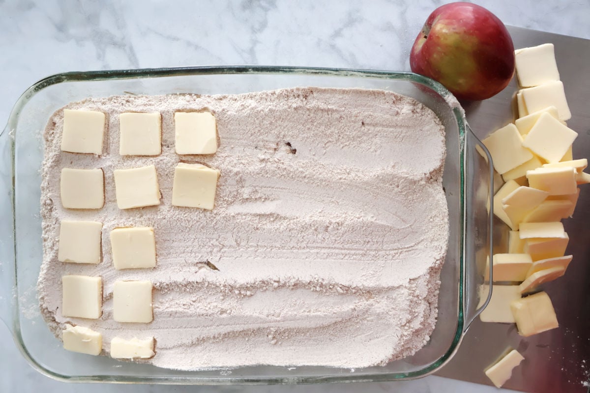 sliced butter spread over layer of spice cake to make the apple spice cake.