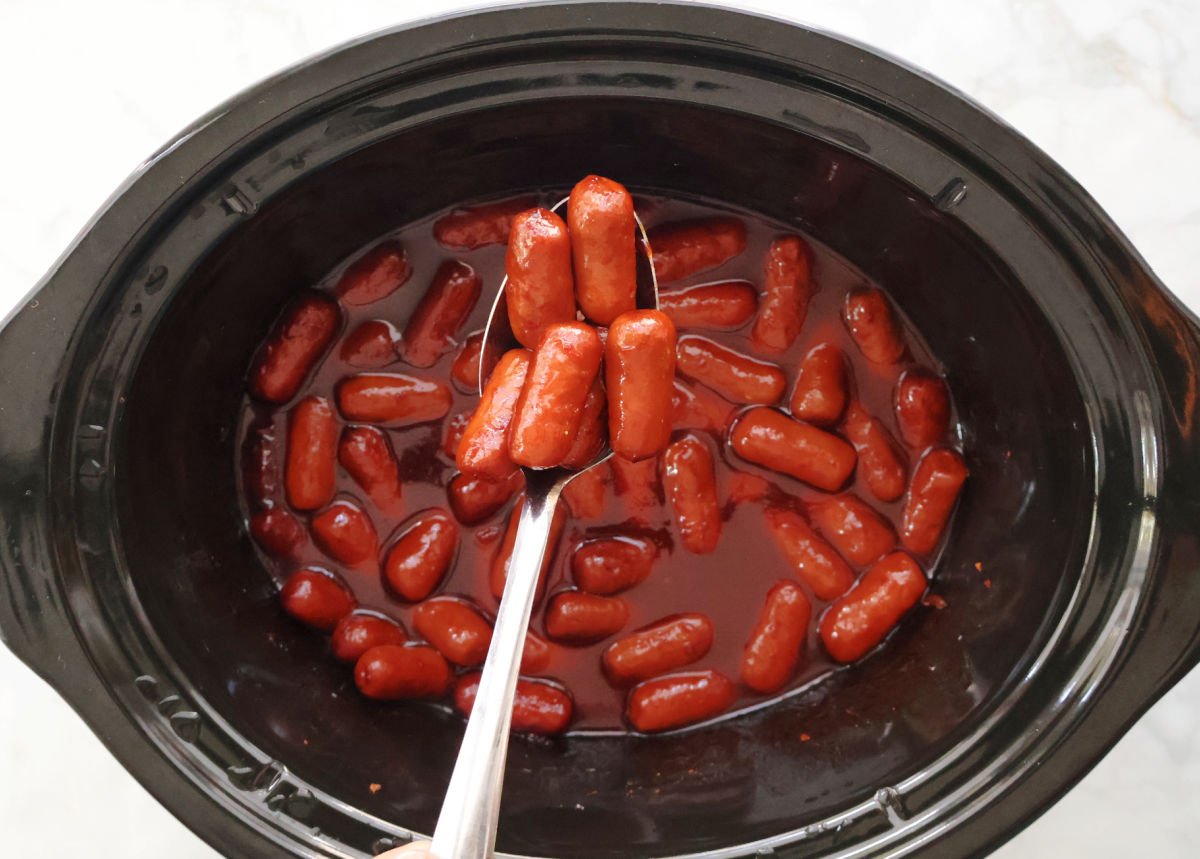 little smokies in a crockpot with grape jelly and chili sauce.