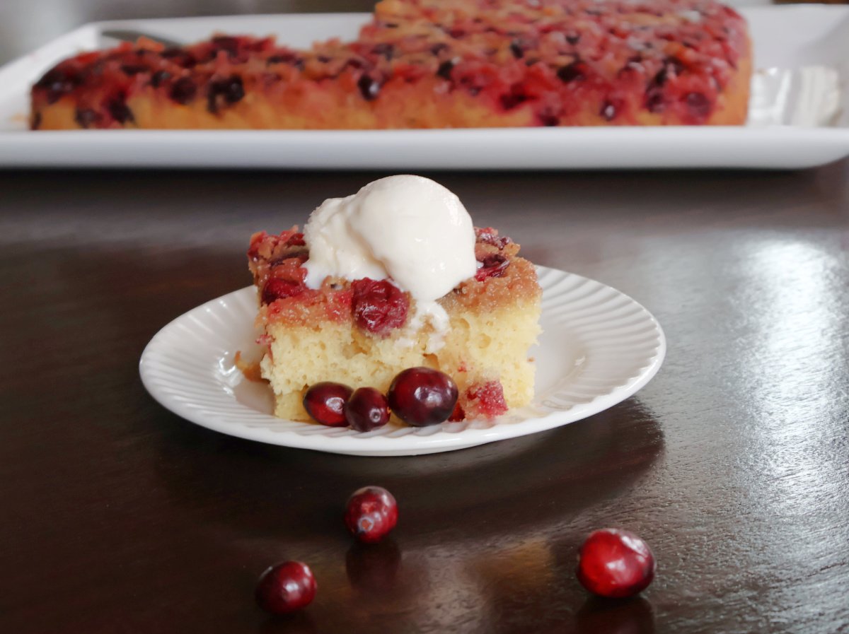 Overhead view of easy cranberry  upside down cake, with a scoop of vanilla ice cream ready to serve for Thanksgiving or Christmas dessert.