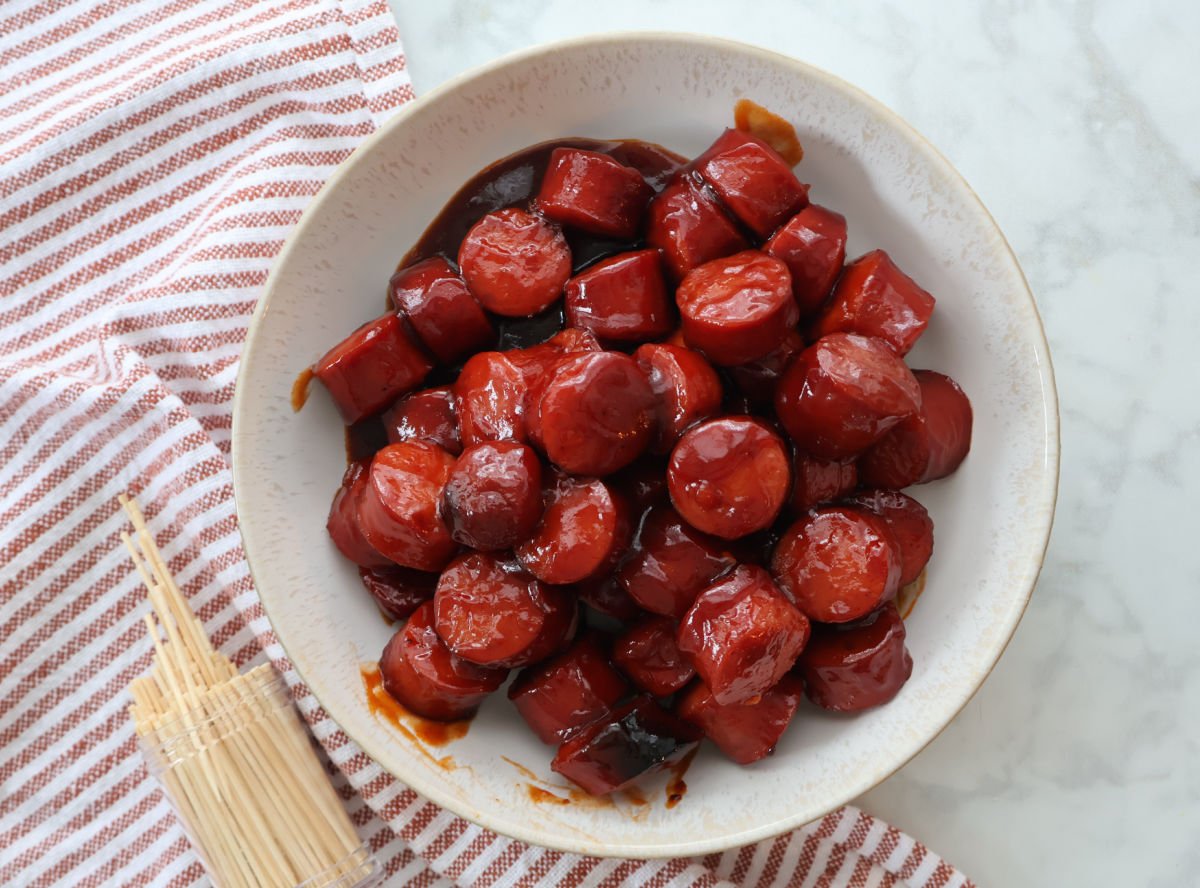 Close-up of glossy BBQ kielbasa with thick sauce.