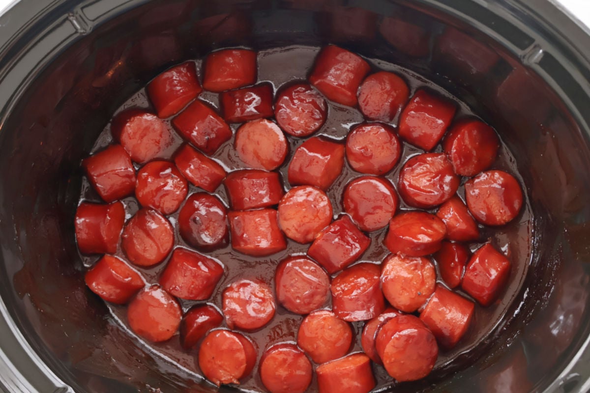 BBQ kielbasa in a slow cooker coated in thick brown sugar barbecue sauce.