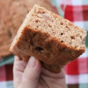 Slice of apple spice cake made with spice cake mix and apple pie filling above the baking pan full of freshly baked are you kidding me cake.