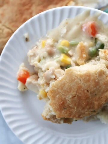 Chicken cobbler casserole with the sauced veggies spilling out from underneath the biscuit mix.