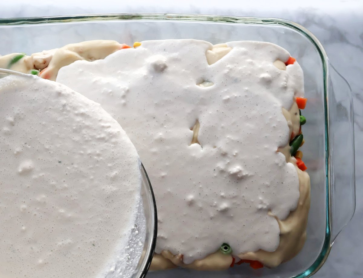 Adding the cheddar bay biscuit mix layer to the chicken cobbler casserole.