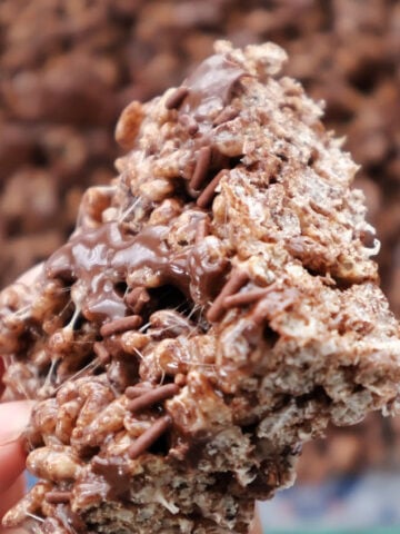 Close-up of chocolate Rice Krispies treats showing the chocolate drizzle and crispy cereal texture.