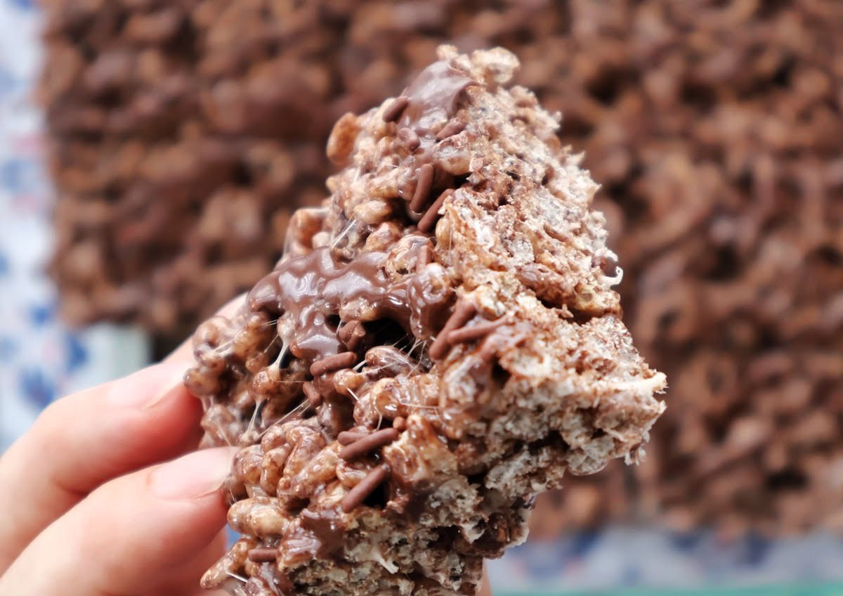 Close-up of chocolate Rice Krispies treats showing the chocolate drizzle and crispy cereal texture.