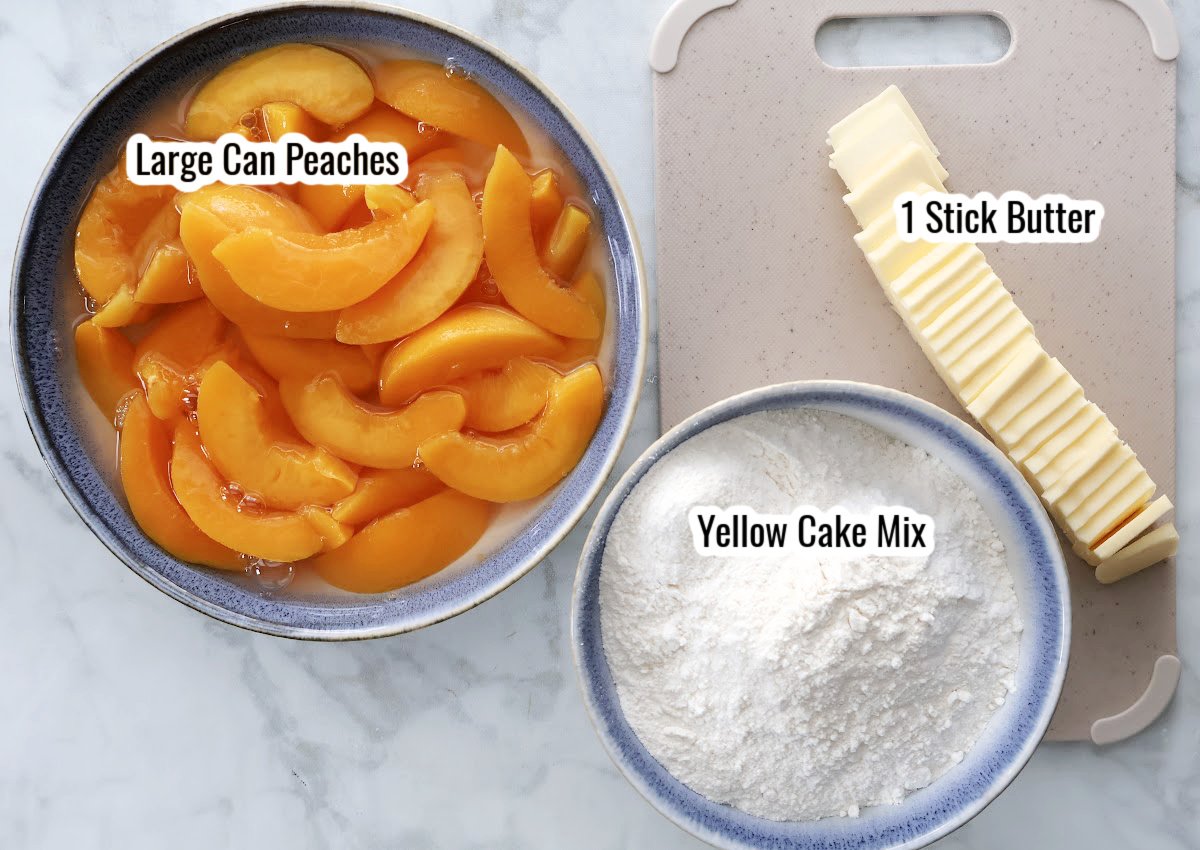 Ingredients for dutch oven peach cobbler including canned peaches, yellow cake mix, and sliced butter on a kitchen counter.