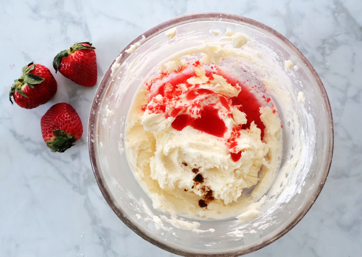 adding strawberry jello to frosting mixture for strawberry jello cake 