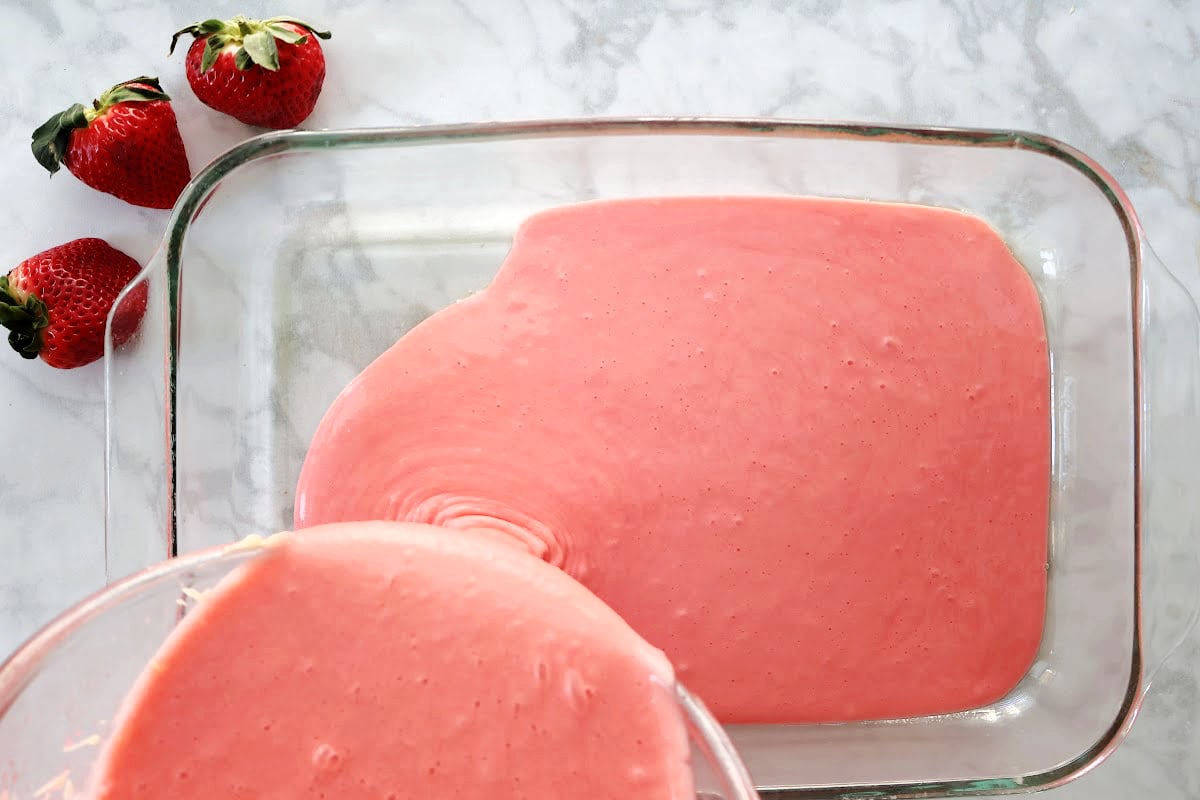 pouring batter for strawberry jello cake into the 9 x 11 baking pan. 