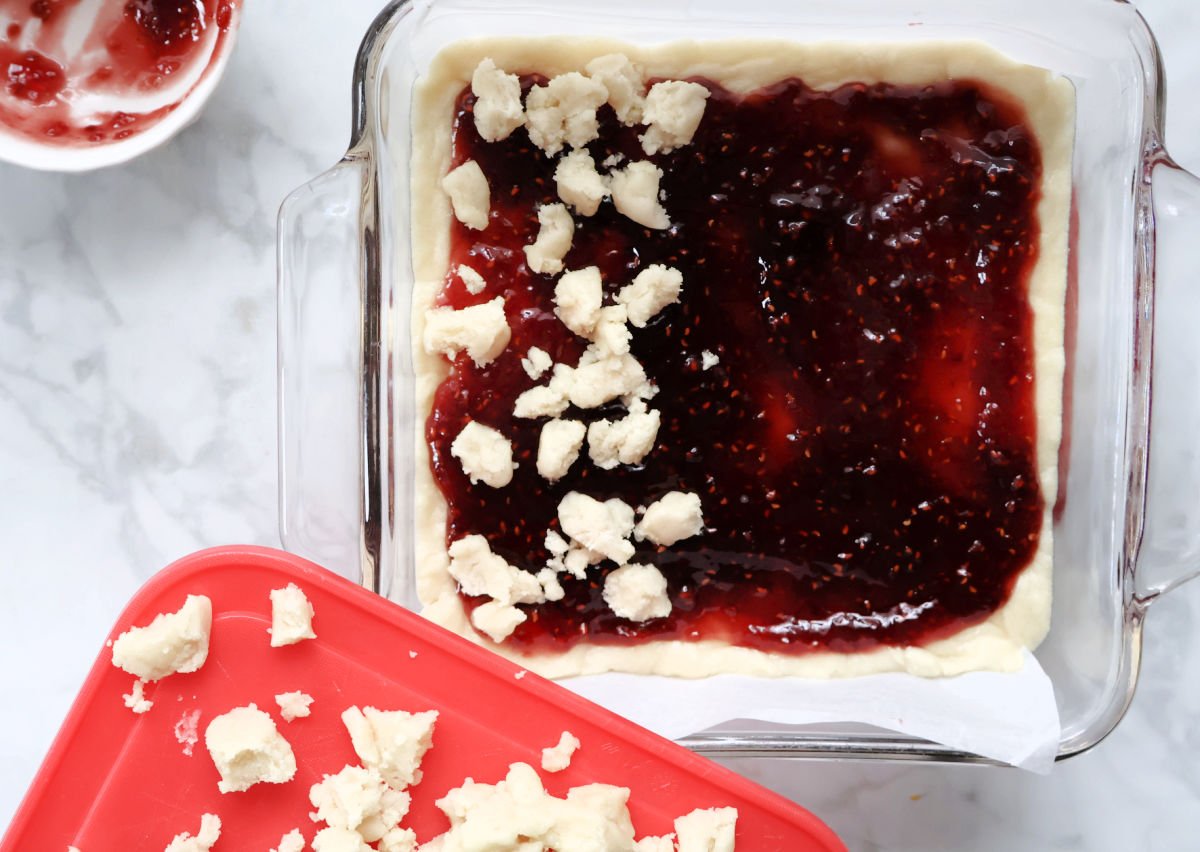 adding crumble topping to raspberry bars