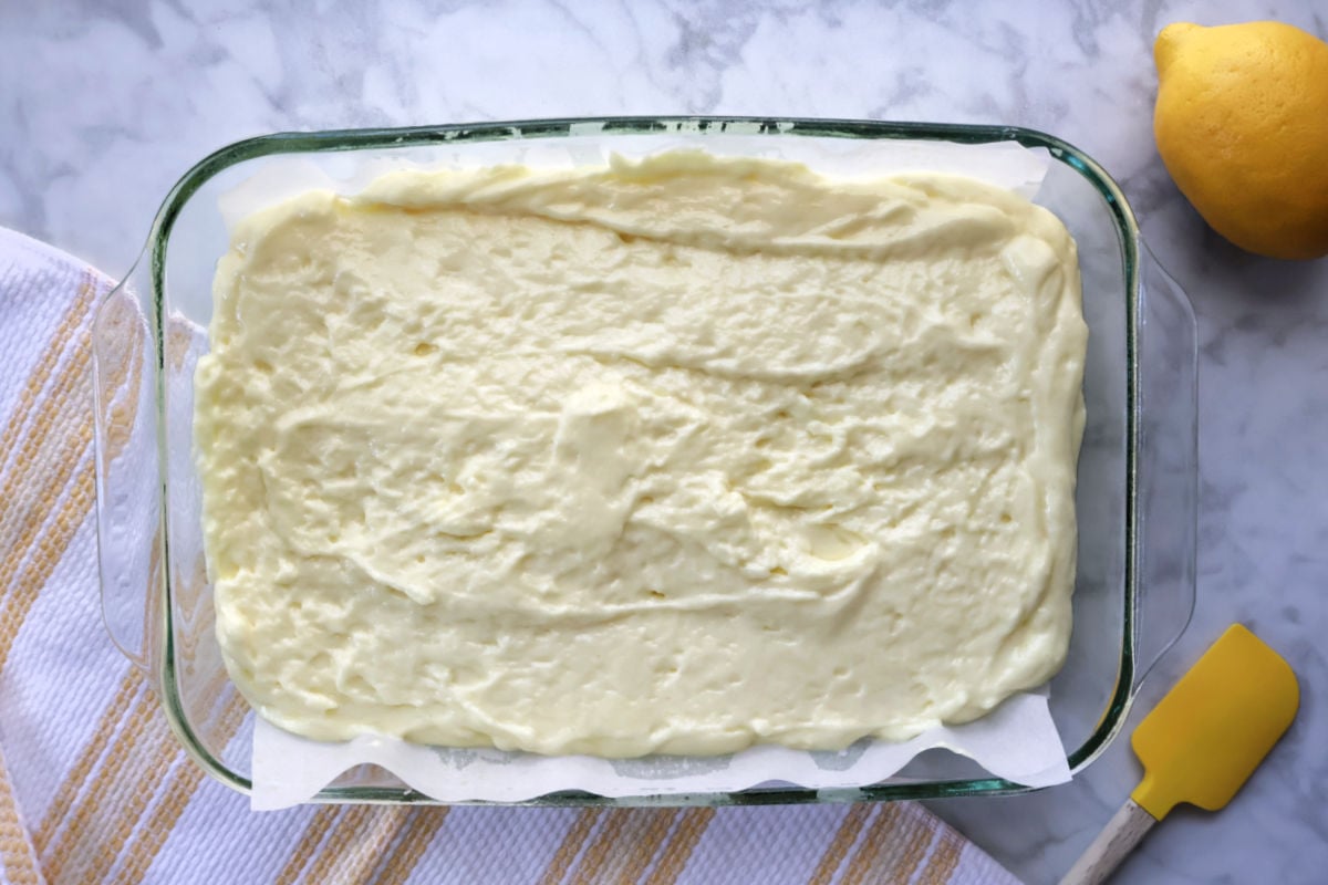 Lemon cake batter spread evenly in a 9x13 baking dish before baking.