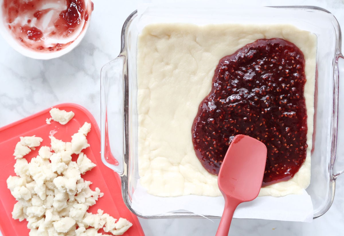 adding raspberry jam to raspberry bars