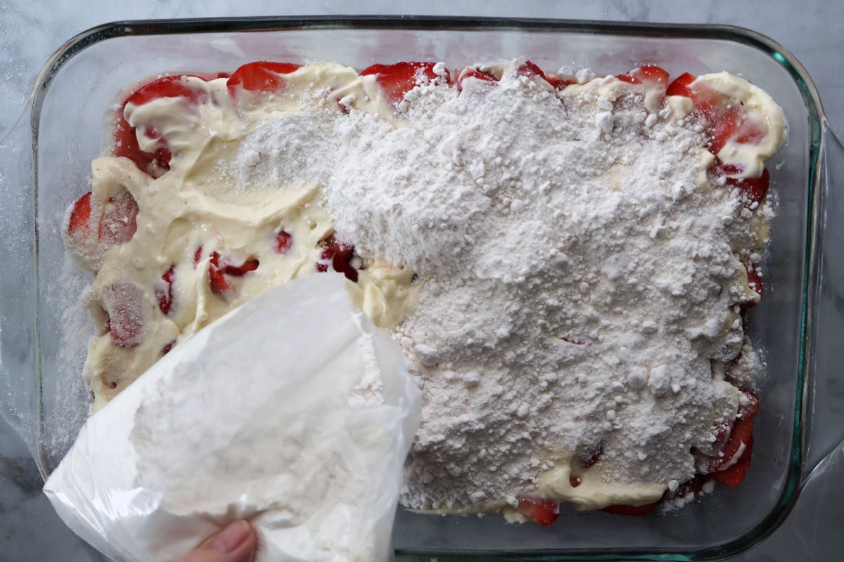 Unbaked strawberry dump cake with melted butter over cake mix