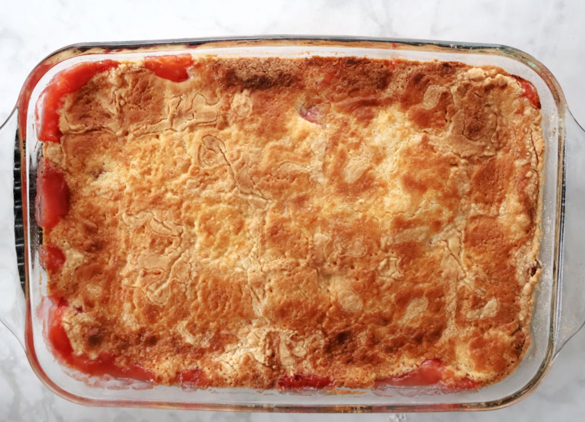 Strawberry cream cheese dump cake baked in a dish with golden topping and juicy strawberry filling