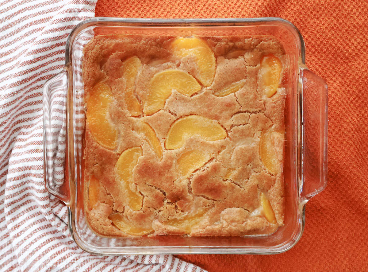 Golden brown Bisquick peach cobbler fresh from the oven in baking dish