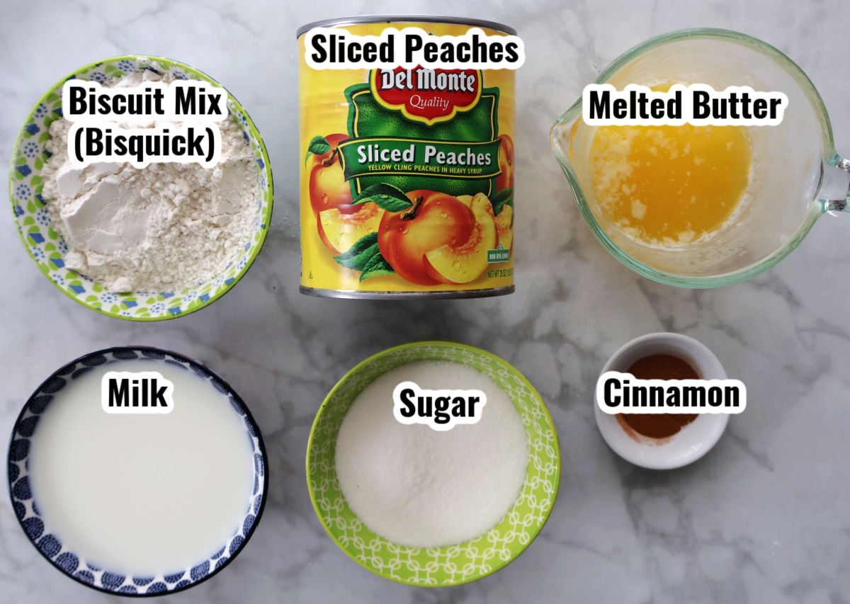 Ingredients for Bisquick peach cobbler including canned peaches, baking mix, milk, butter, sugar, and cinnamon
