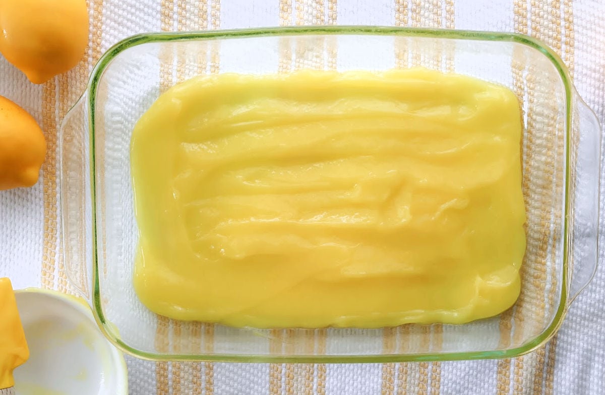 Lemon curd spread evenly in baking dish for dump cake base