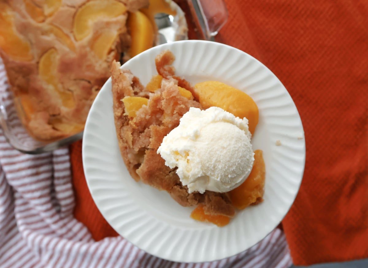 Serving of peach cobbler with canned peaches topped with vanilla ice cream